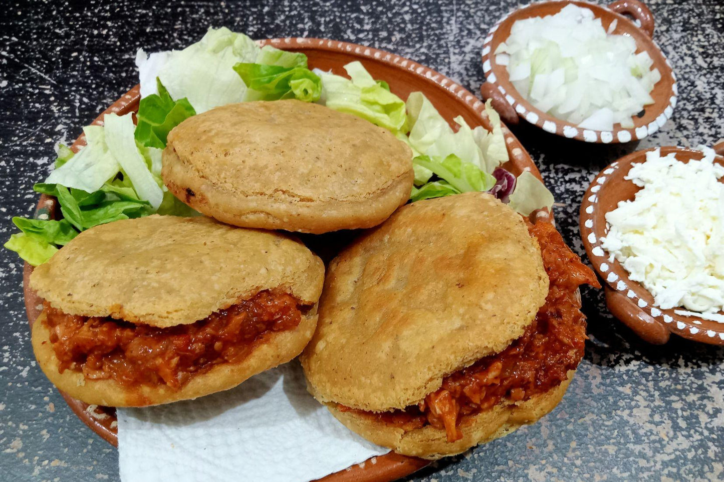 tres gorditas de chicharron sobre plato de barro
