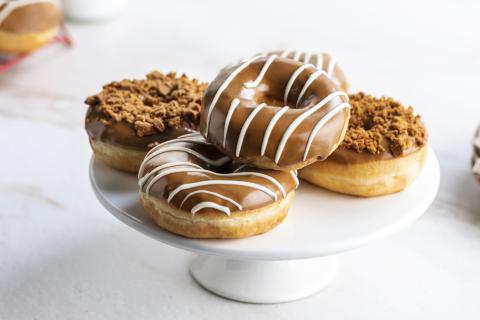 fuente de cerámica blanca con cuatro donuts bañados en chocolate y crema de untar lotus biscoff