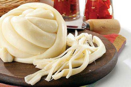 bola e hilos de queso de oaxaca sobre tabla de madera