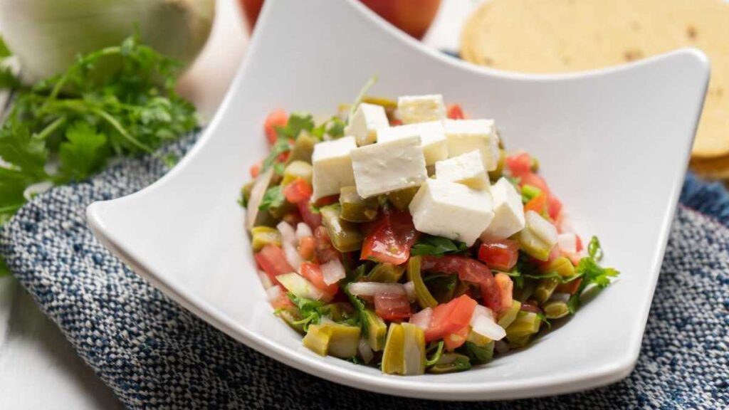 cuenco blanco con ceviche adornado con queso panela en tacos