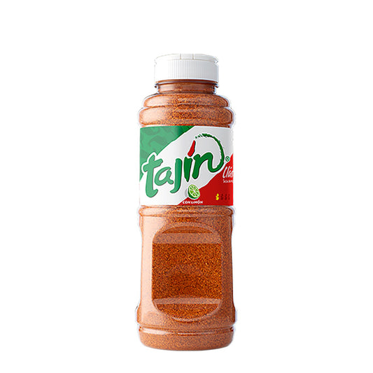 Envase plástico transparente de la marca Tajín en el que se aprecia el color anaranjado de las sal de chile, tapón blanco y una etiqueta con los colores verde, blanco y rojo de la bandera mexicana.