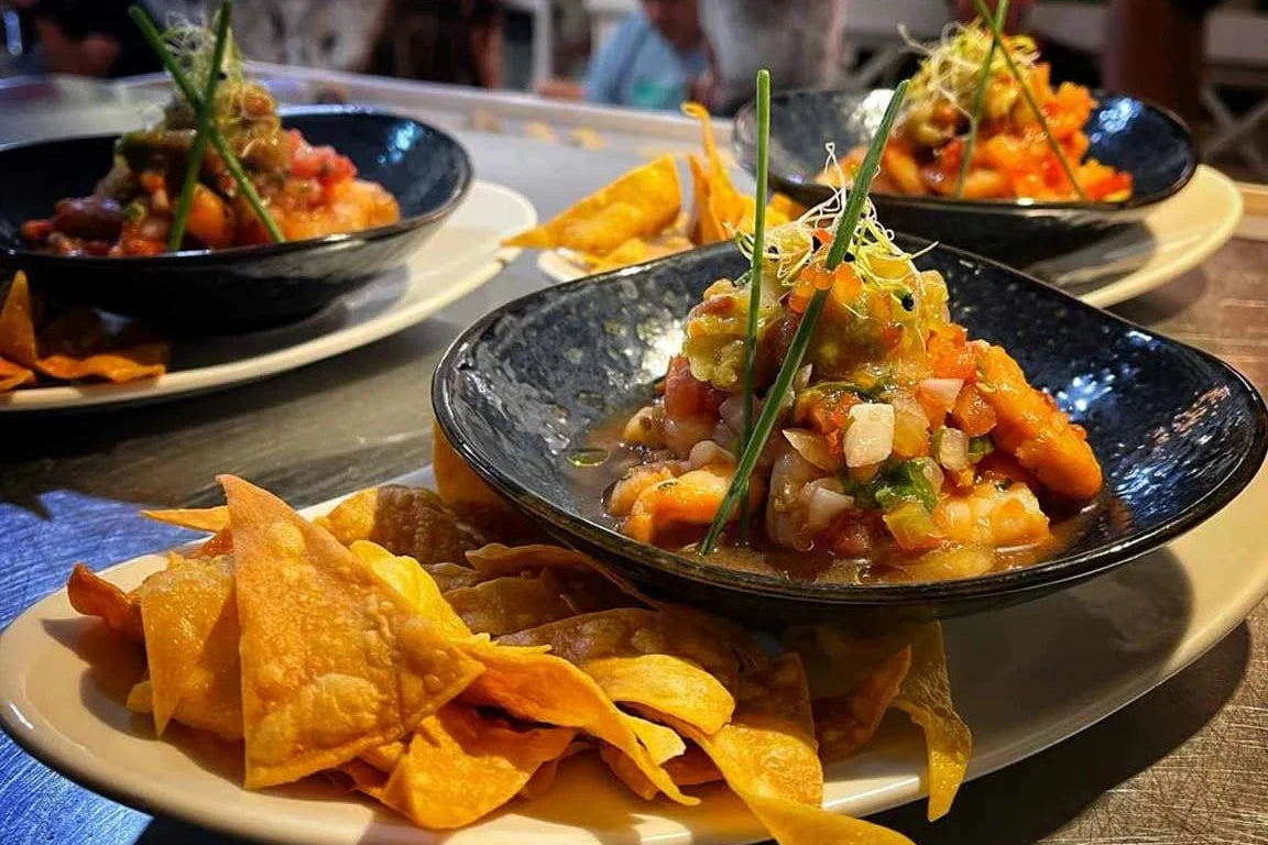 Ceviche fresco servido con totopos en platos individuales. Ideal para disfrutar en reuniones.