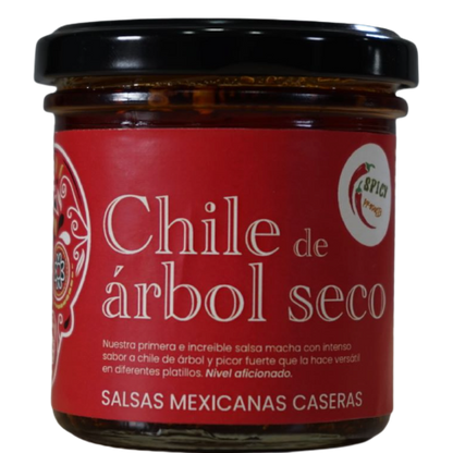 Frasco de salsa macha con chile de árbol seco. Etiqueta roja con calavera mexicana ilustrada.