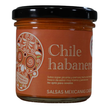 Frasco de salsa cremosa de chile habanero. Etiqueta naranja con ilustración de calavera mexicana tradicional.