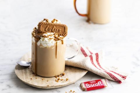 Taza de chocolate con nata y sobre esta una galleta lotus