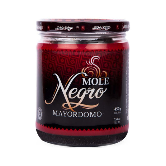 Frasco de mole negro Mayordomo de 450 g, mostrando un diseño artesanal y detalles en rojo y negro.