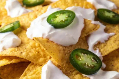 Nachos simples con jalapeños frescos en rodajas y crema, servidos como una botana deliciosa y rápida