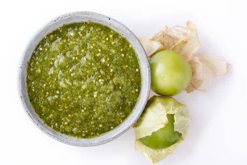 Plato con salsa verde de tomatillo y tomatillos frescos pelados. Ideal para tacos, enchiladas y recetas mexicanas tradicionales.