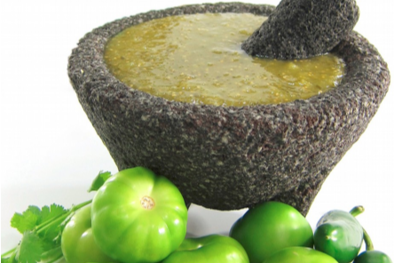 Salsa verde casera en molcajete con tomatillos frescos, jalapeños y cilantro, ideal para platillos tradicionales mexicanos.