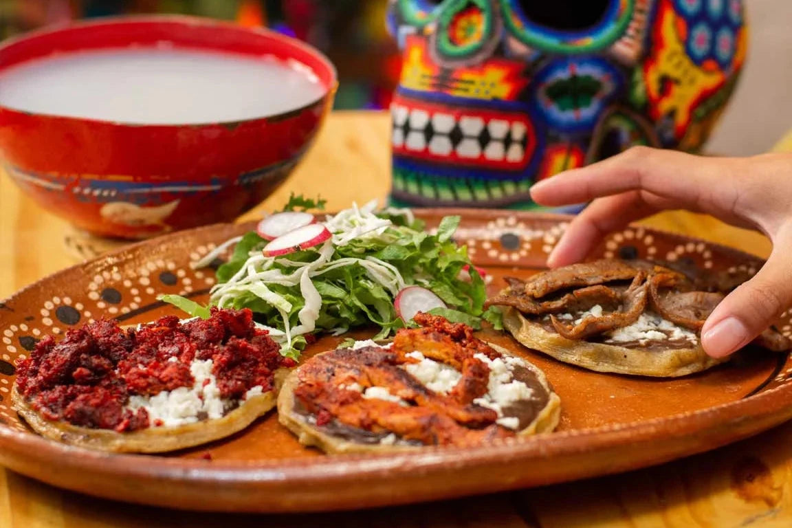 Plato tradicional mexicano con sopes decorados con chorizo, queso y verduras frescas