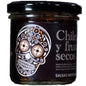 Envase de vidrio con salsa macha de chile y frutos secos. Diseño con calavera mexicana decorativa.